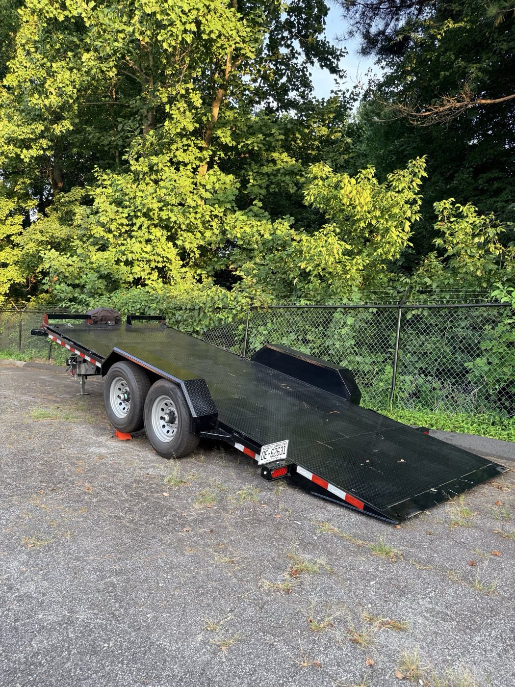 Rear view of the hauler with the deck tilted to the ground, knife-edge tail down