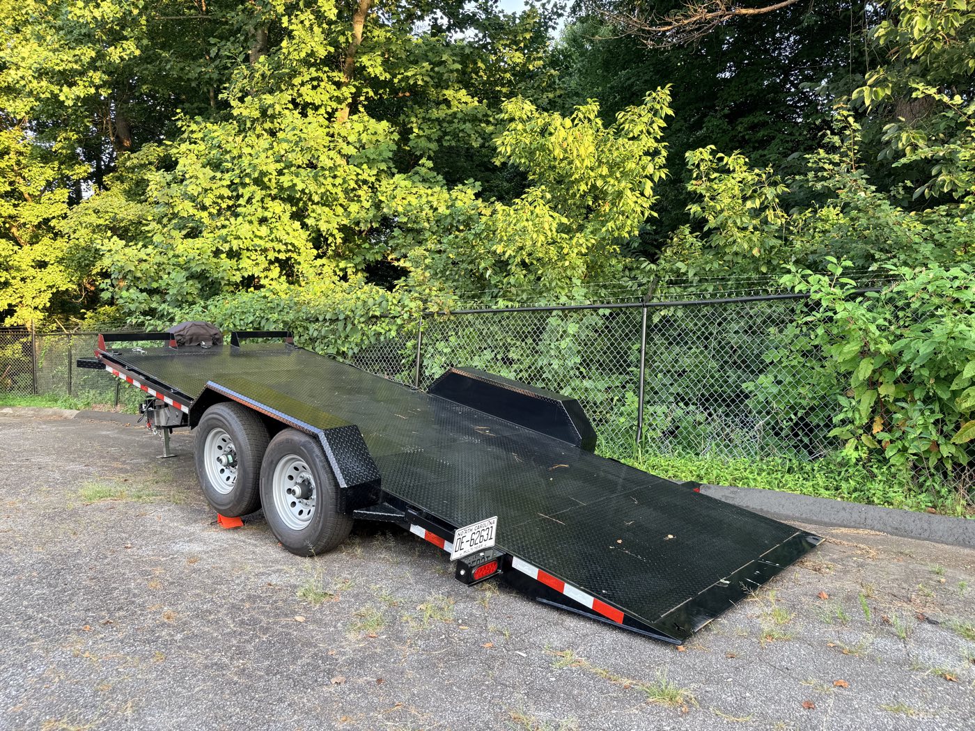 The hauler with its deck power-tilted down to the ground for loading